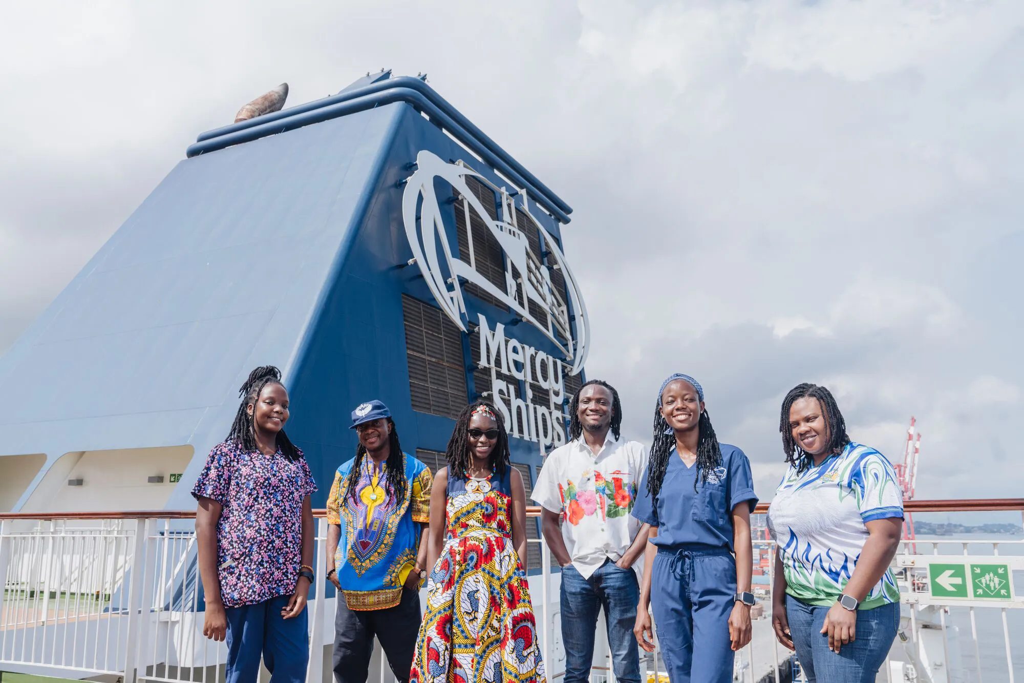 Personas sonriendo desde el buque de Mercy Ships